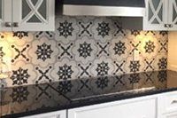 Une cuisine avec des armoires blanches, des comptoirs noirs et une cuisinière noire.