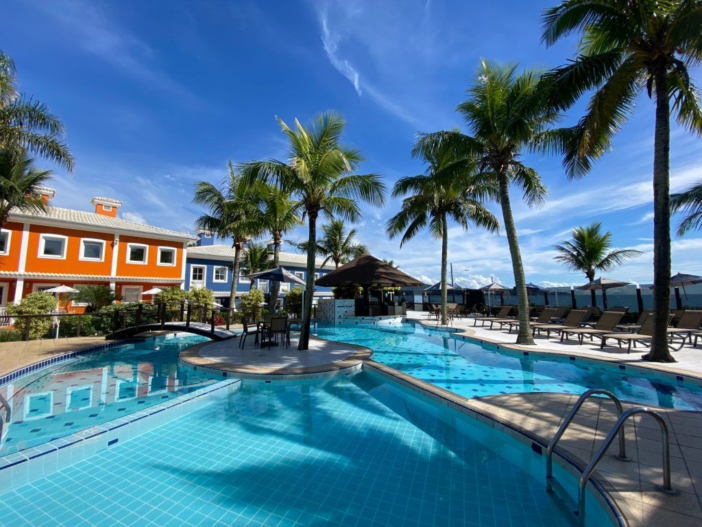 Uma grande piscina cercada por palmeiras em um resort.