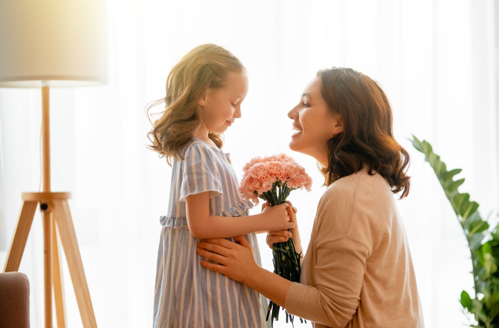 Uma garotinha está dando um buquê de flores para sua mãe.