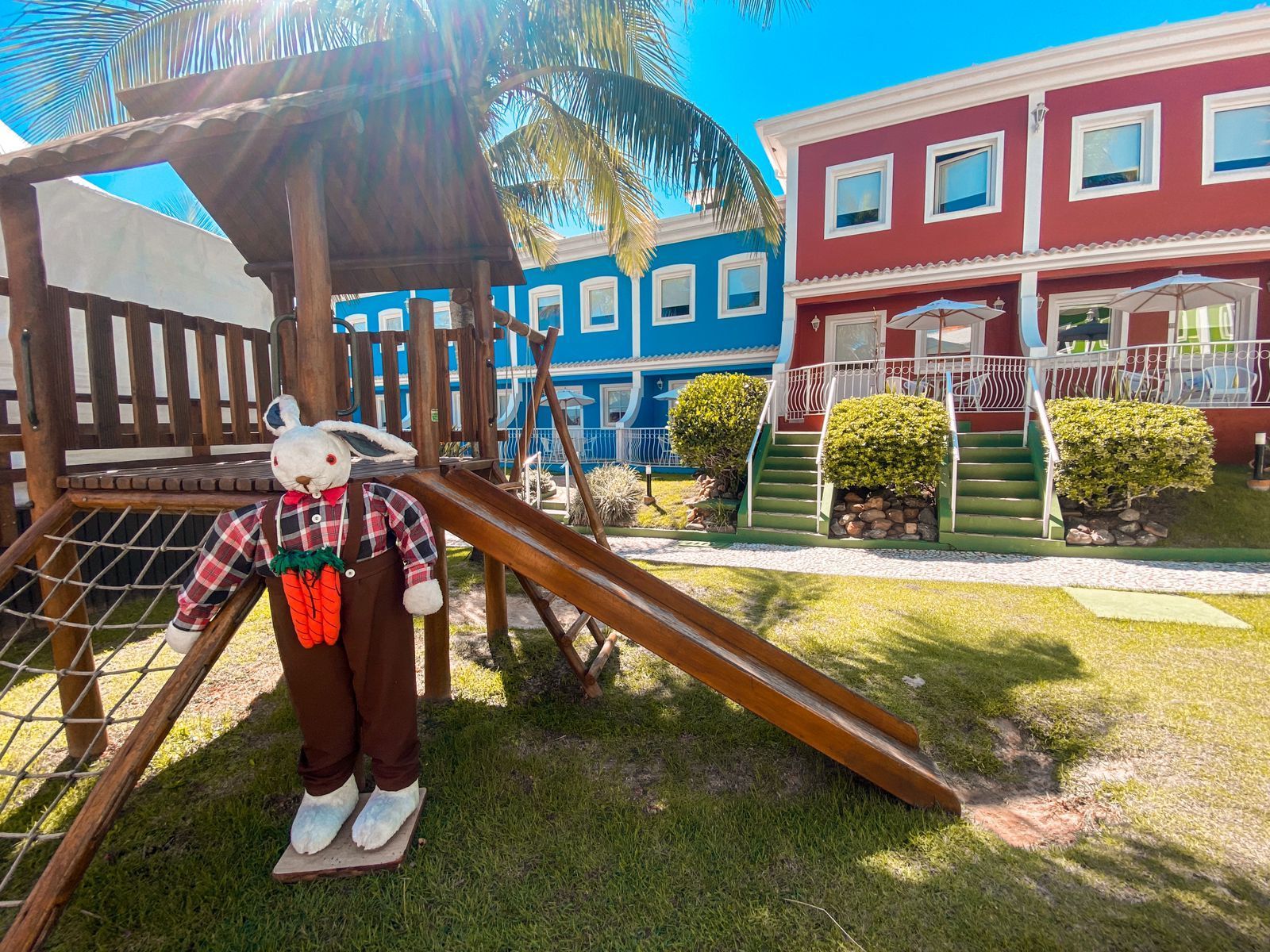 Um playground de madeira com um coelho de pelúcia em cima.