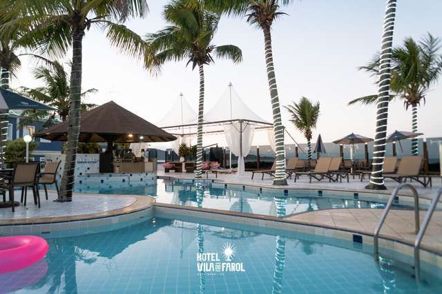 Uma grande piscina cercada por palmeiras e guarda-sóis em um hotel