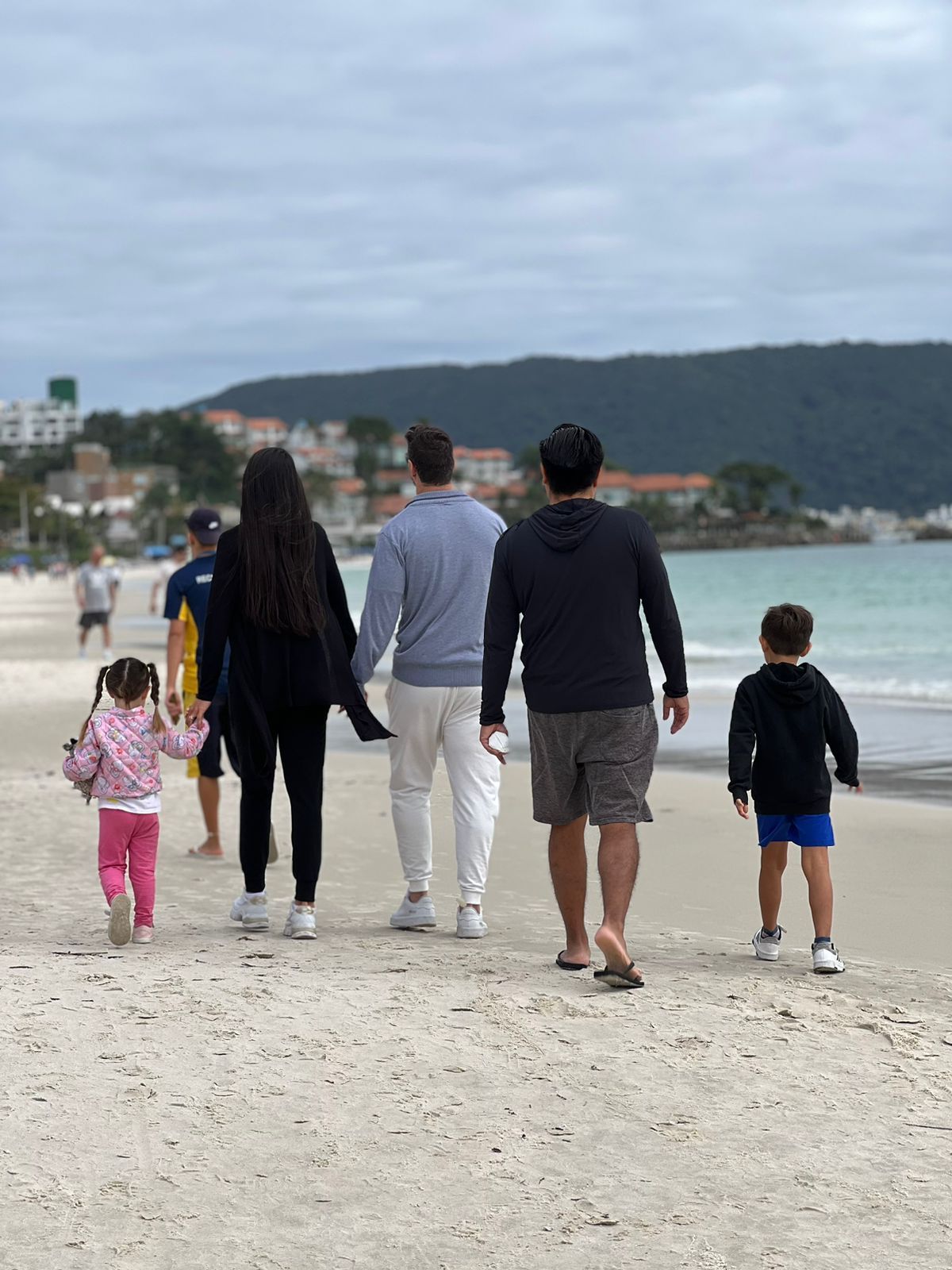 Um grupo de pessoas está caminhando na praia.