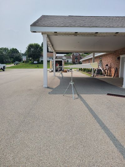 Red tile roof with brick chimney against a blue sky.