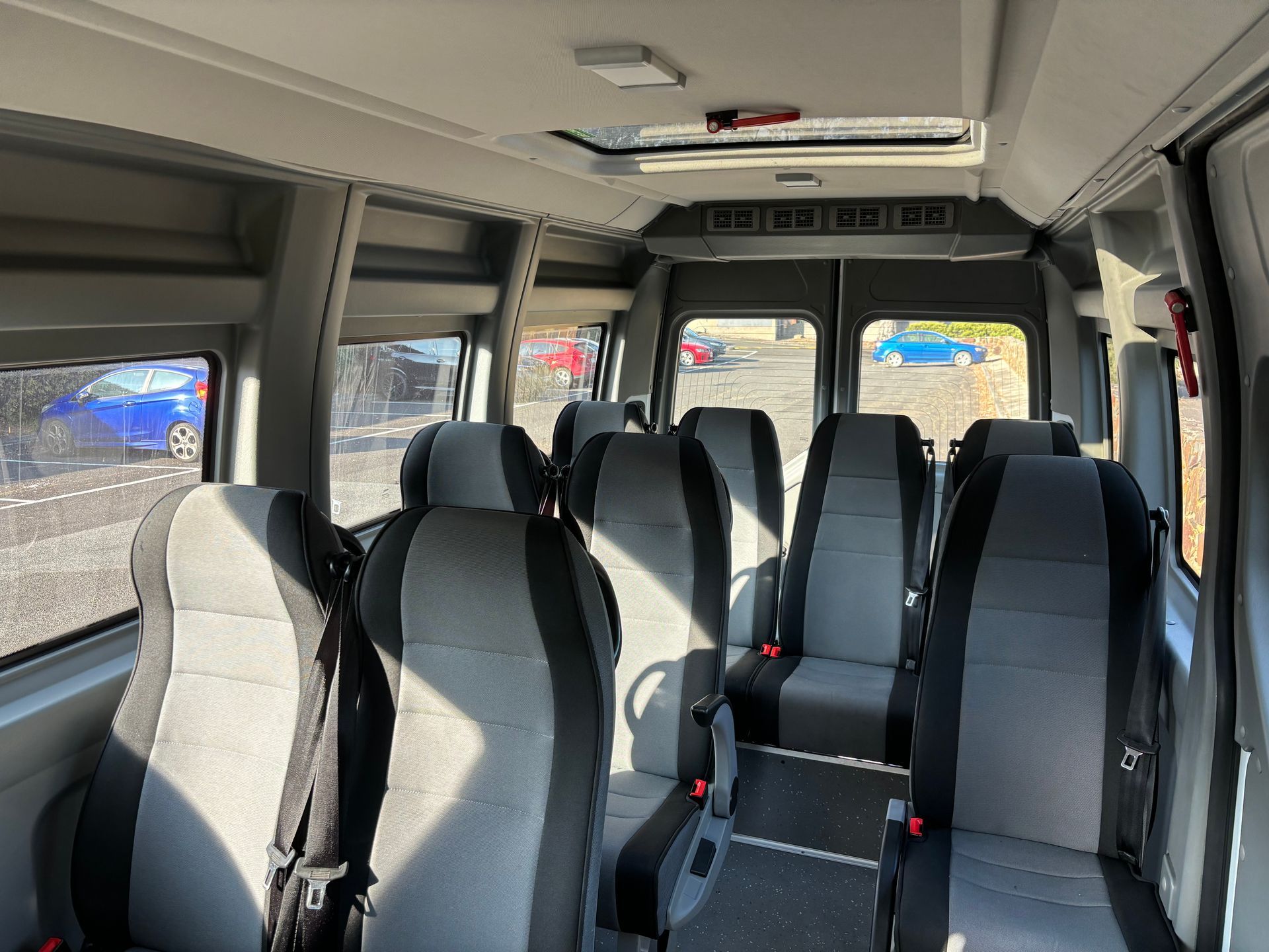Interior view of a Ticket 2 Ride minibus, showing  seating positions and lots  of light through the windows and sunroof