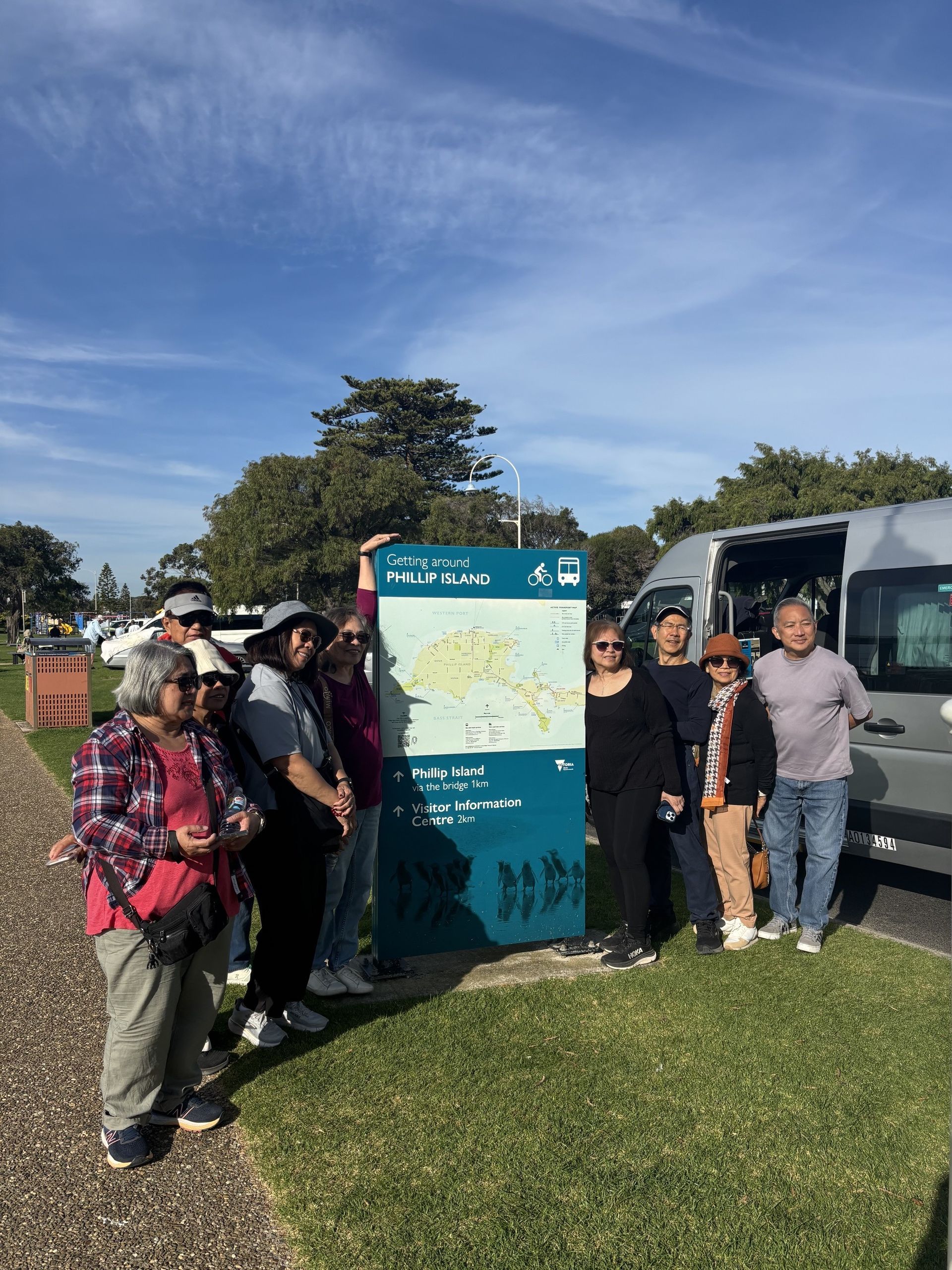 A group of friends standing beside a tourist directional sign in San Remo, just before Phillip Island