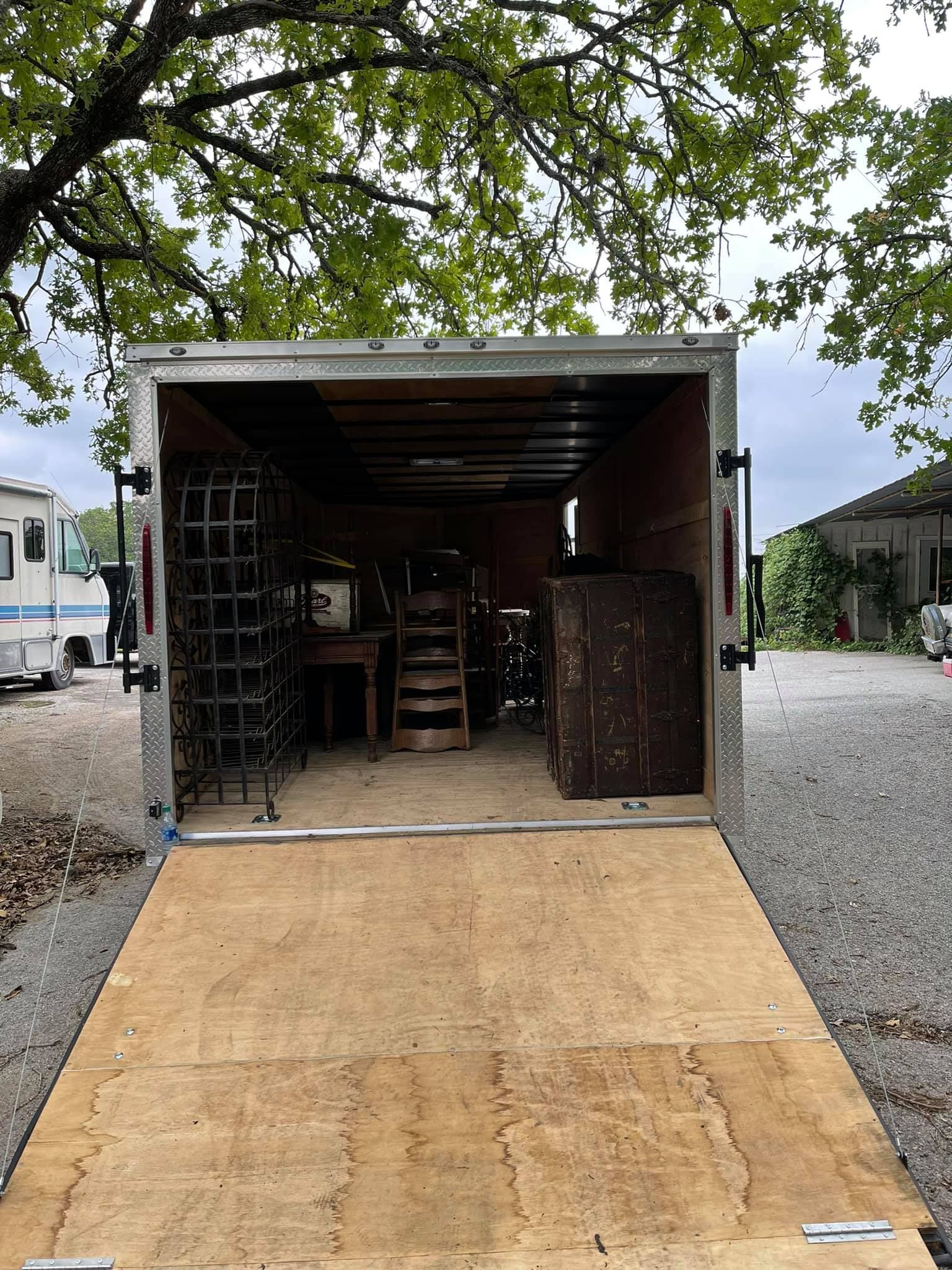 The inside of a trailer with a wooden floor and a wooden ramp.
