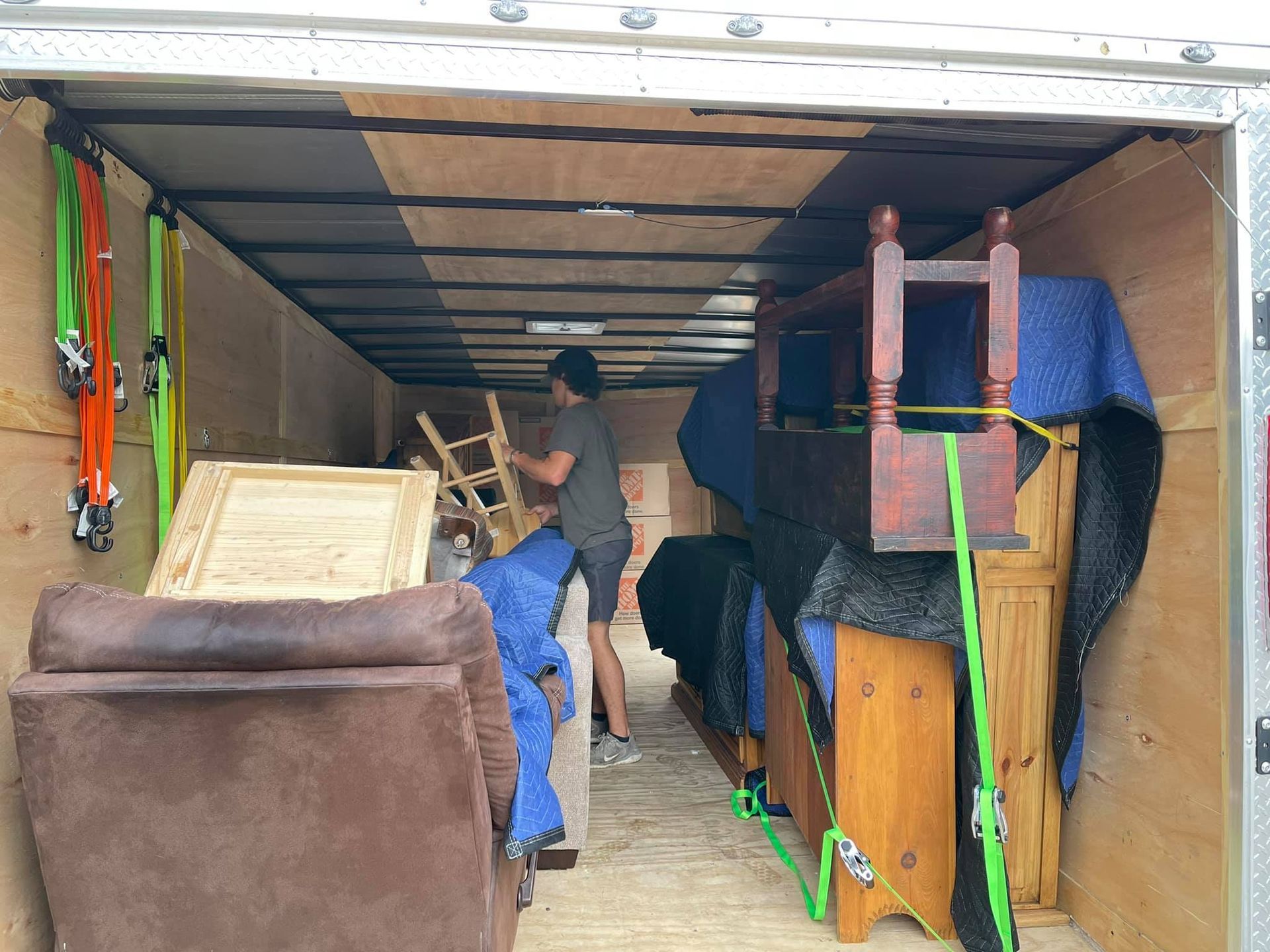 A man is loading furniture into a moving truck.