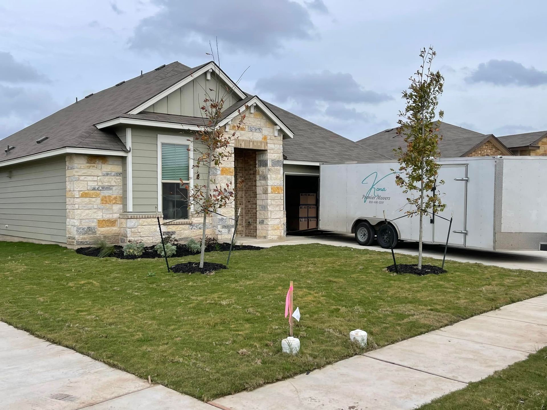A house with a trailer parked in front of it.