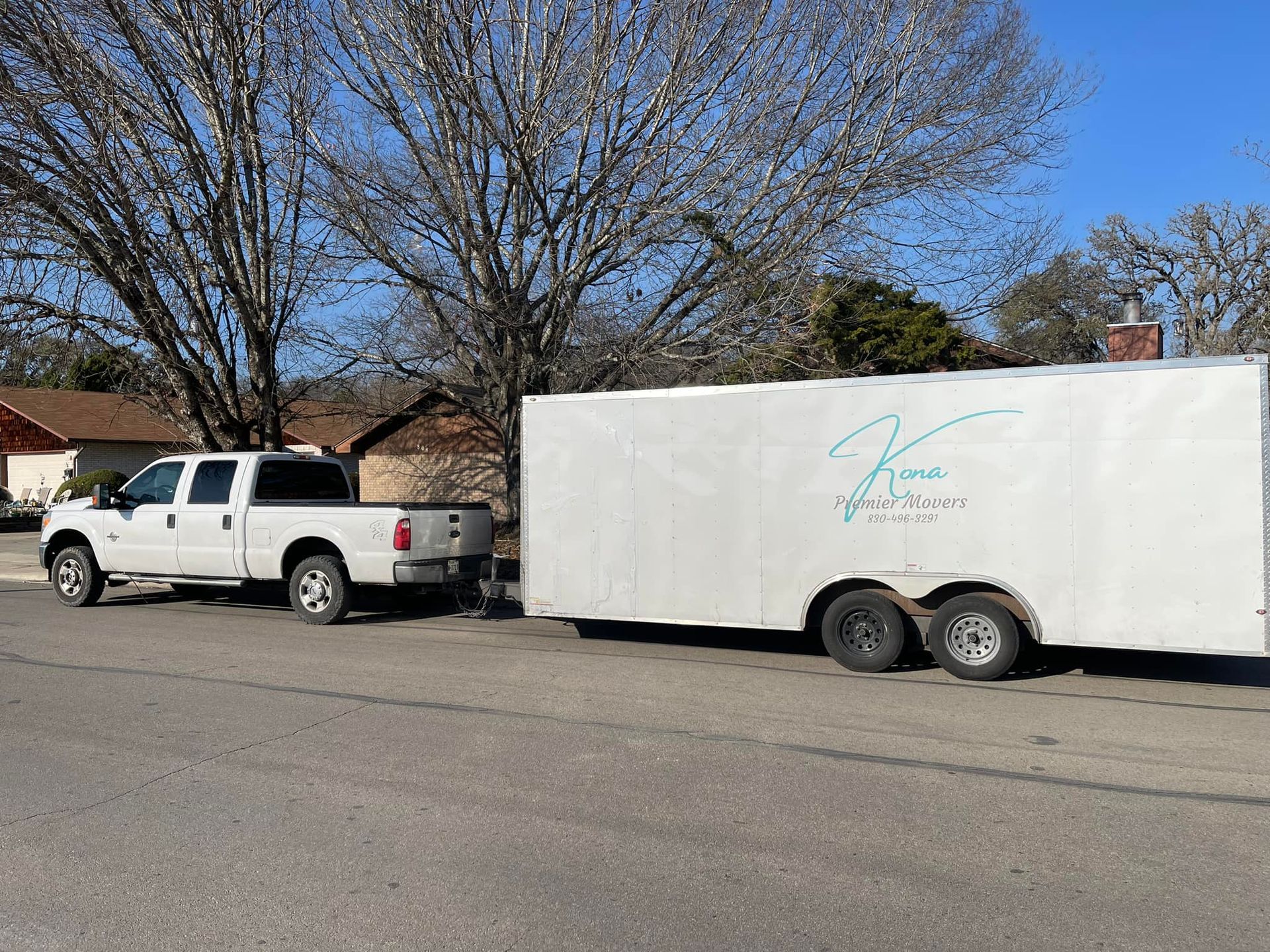 A truck and trailer are parked on the side of the road.