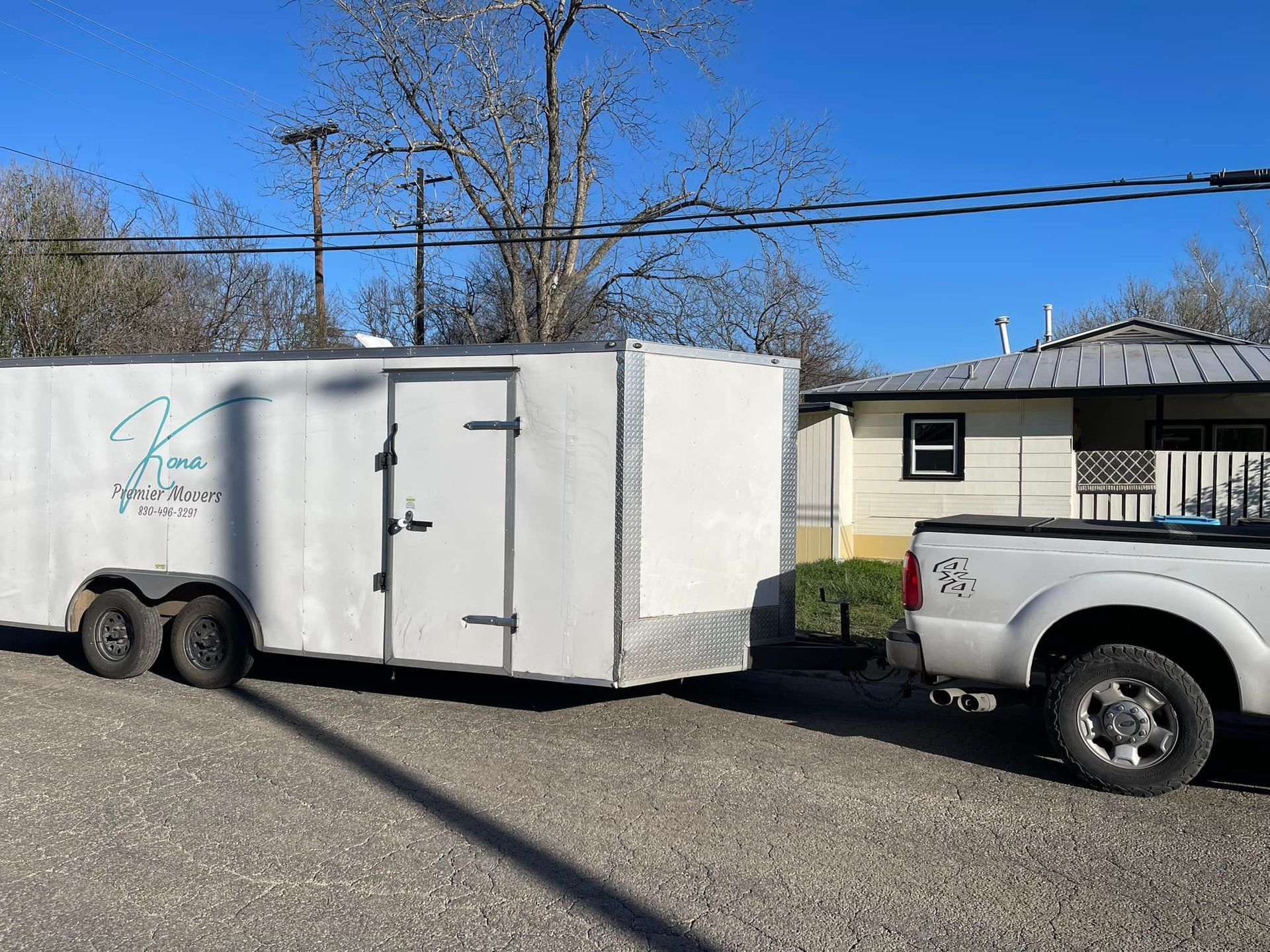 A white trailer is being towed by a white truck.