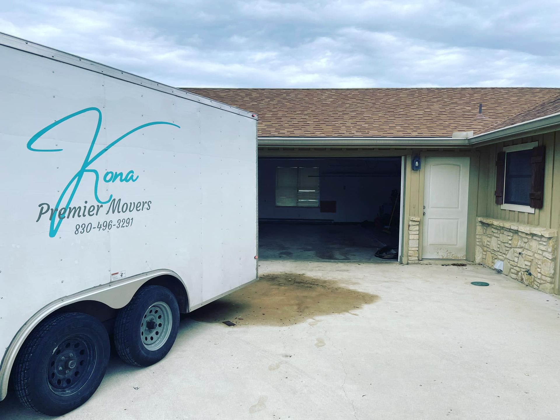 A white trailer with the word premier on it is parked in front of a house.