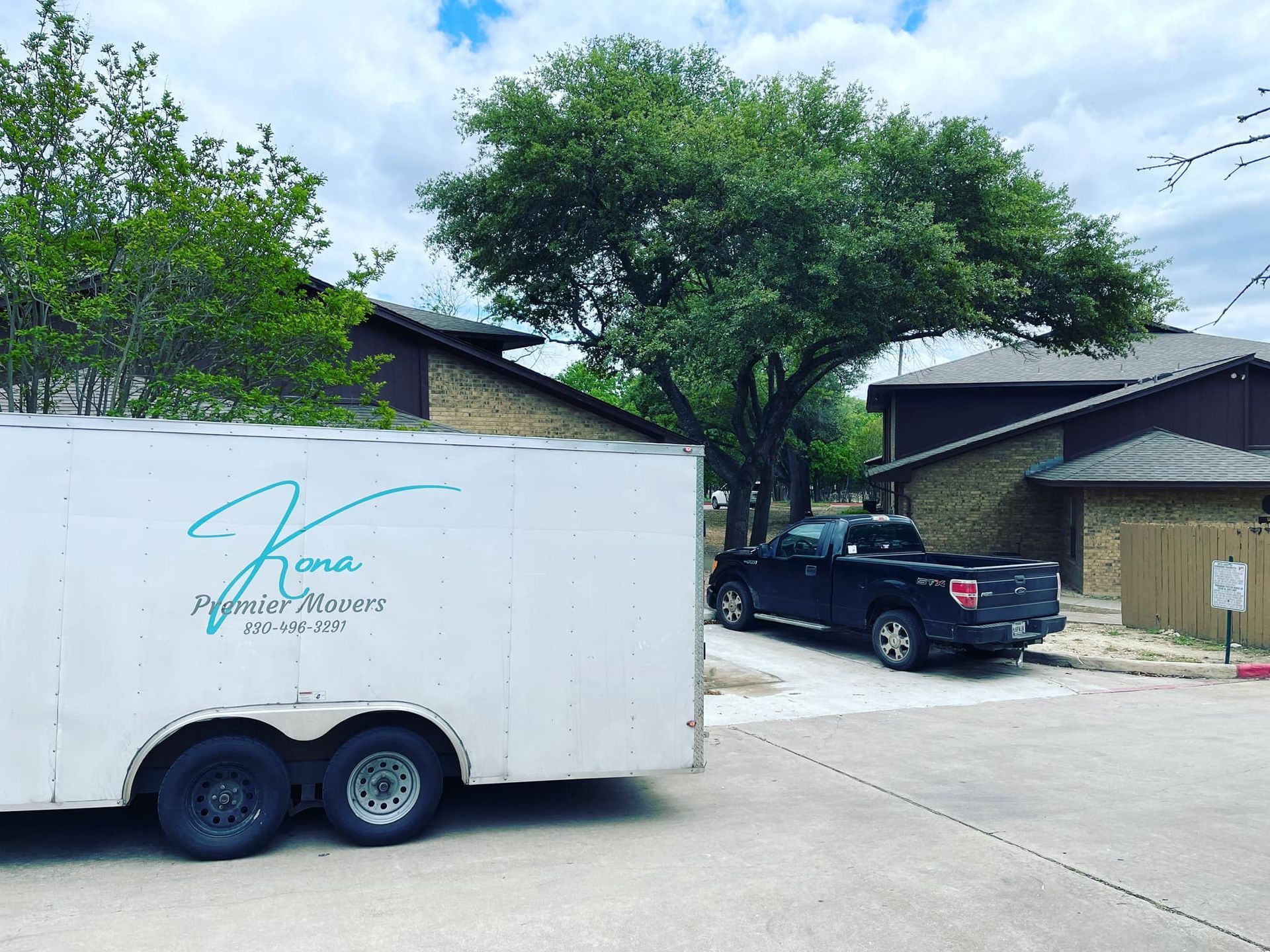A white trailer is parked in front of a house.
