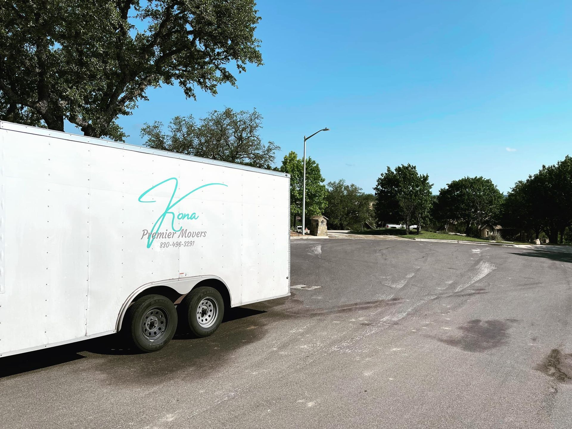 A white trailer is parked in a parking lot.
