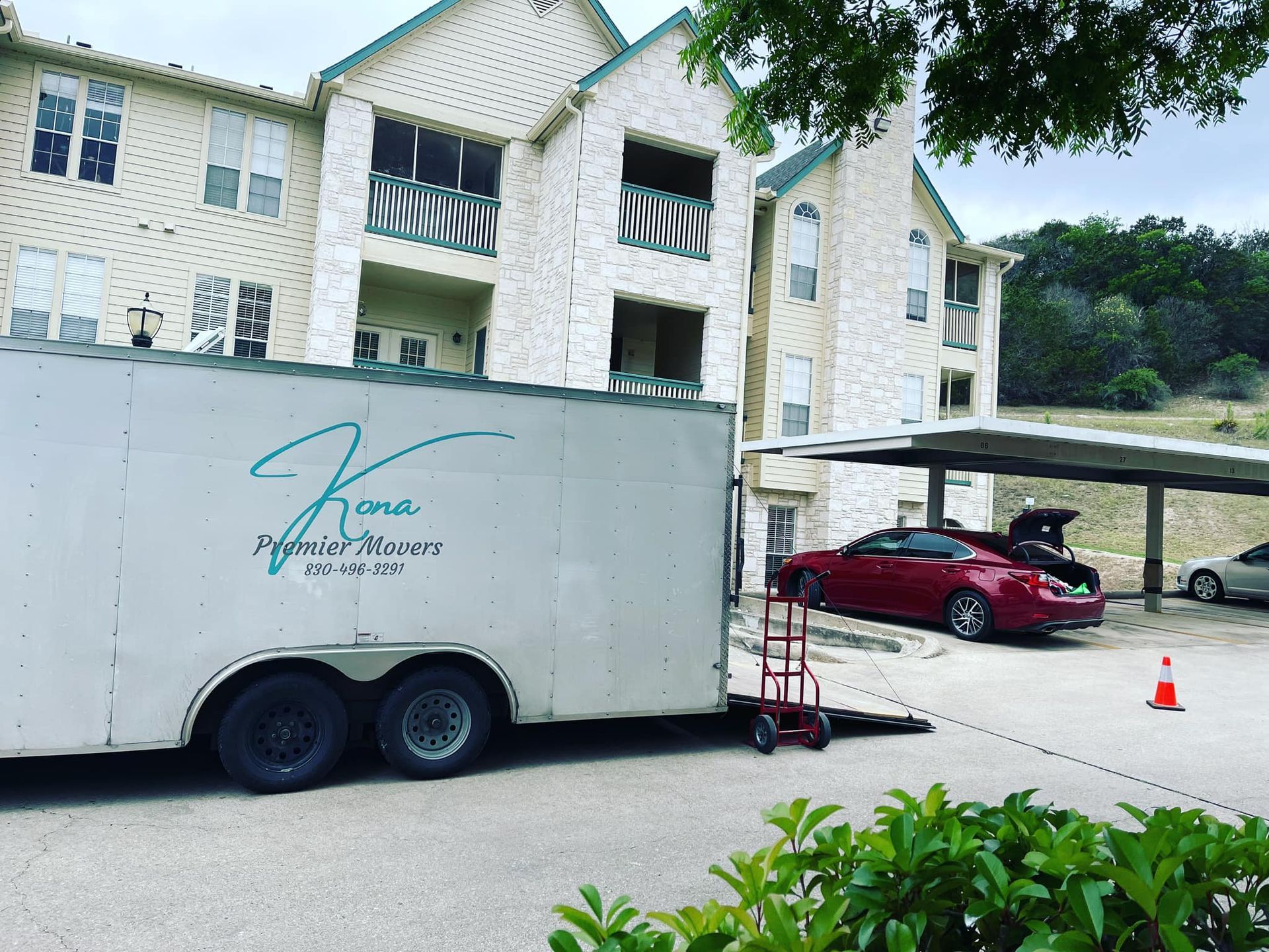 A white trailer is parked in front of a building.