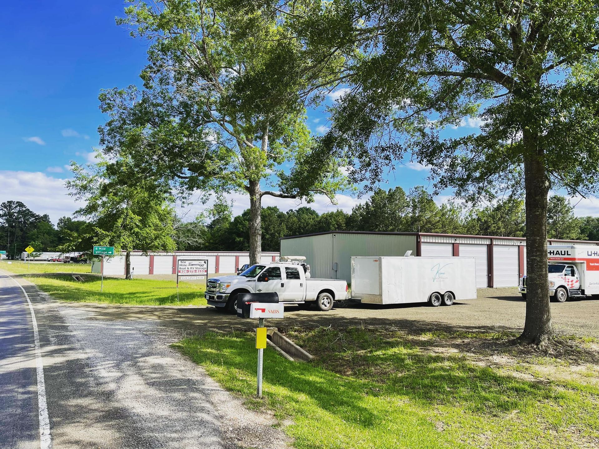 A truck is parked on the side of the road next to a trailer.