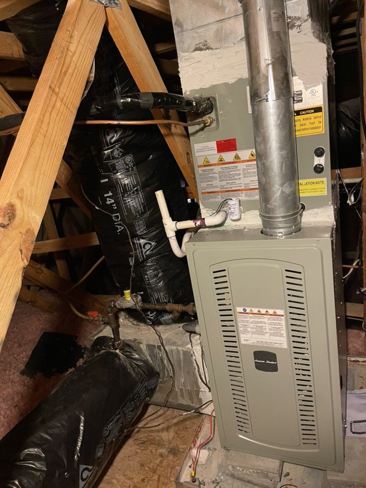 A furnace is sitting in the attic of a house.