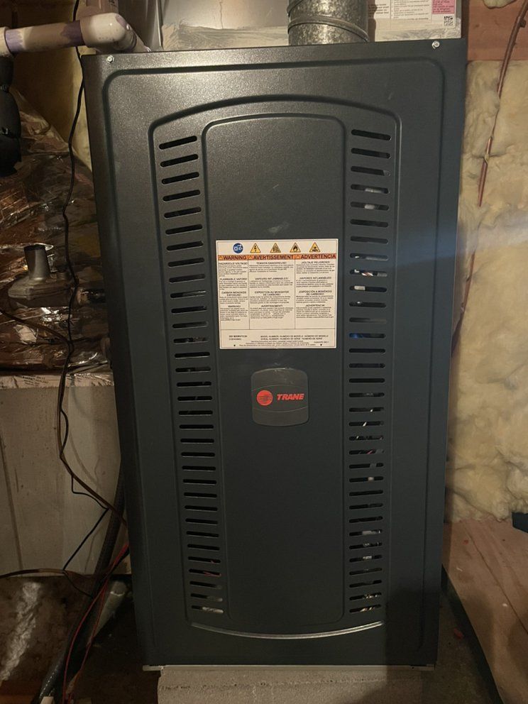 A gas furnace is sitting in the basement of a house.