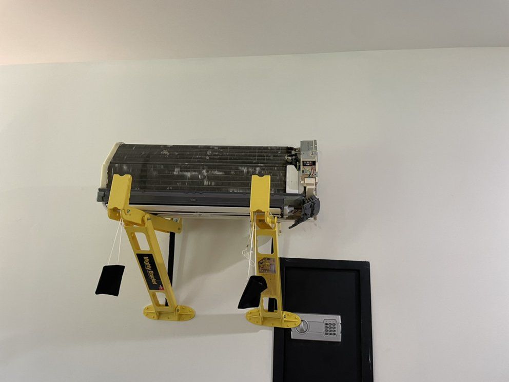 A yellow ladder is attached to a wall next to an air conditioner.