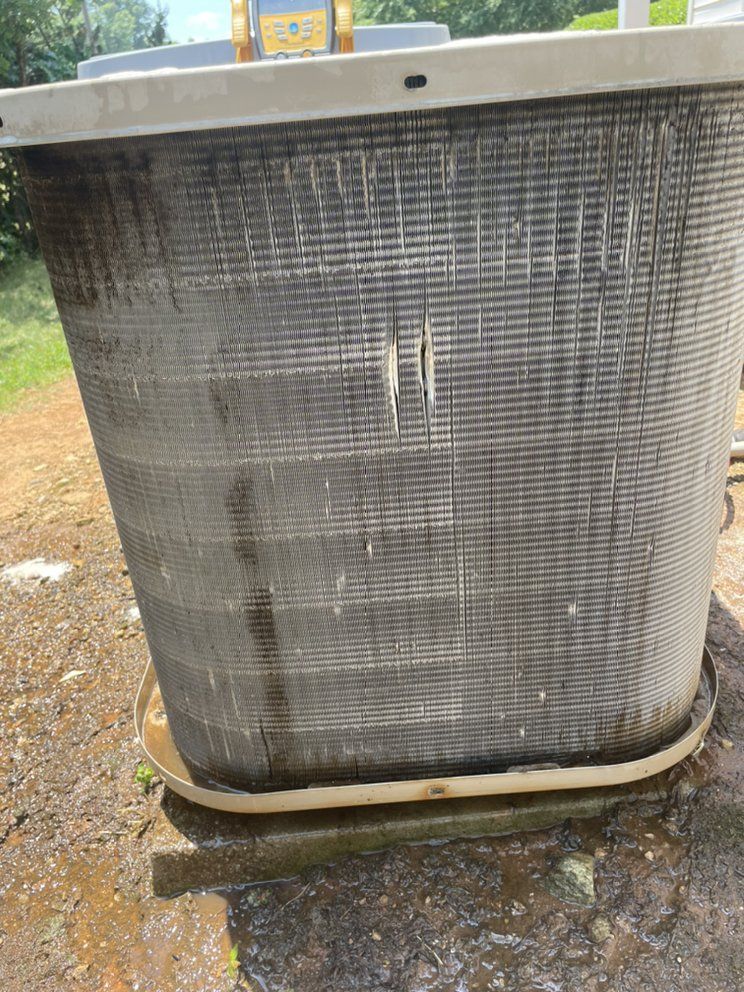 A large gray container is sitting on top of a dirt field.
