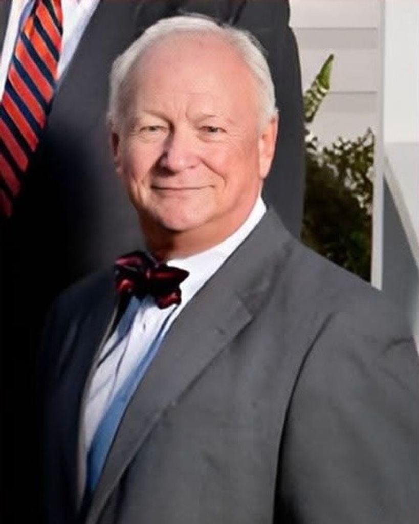 A woman wearing a white shirt and a pink necklace smiles for the camera