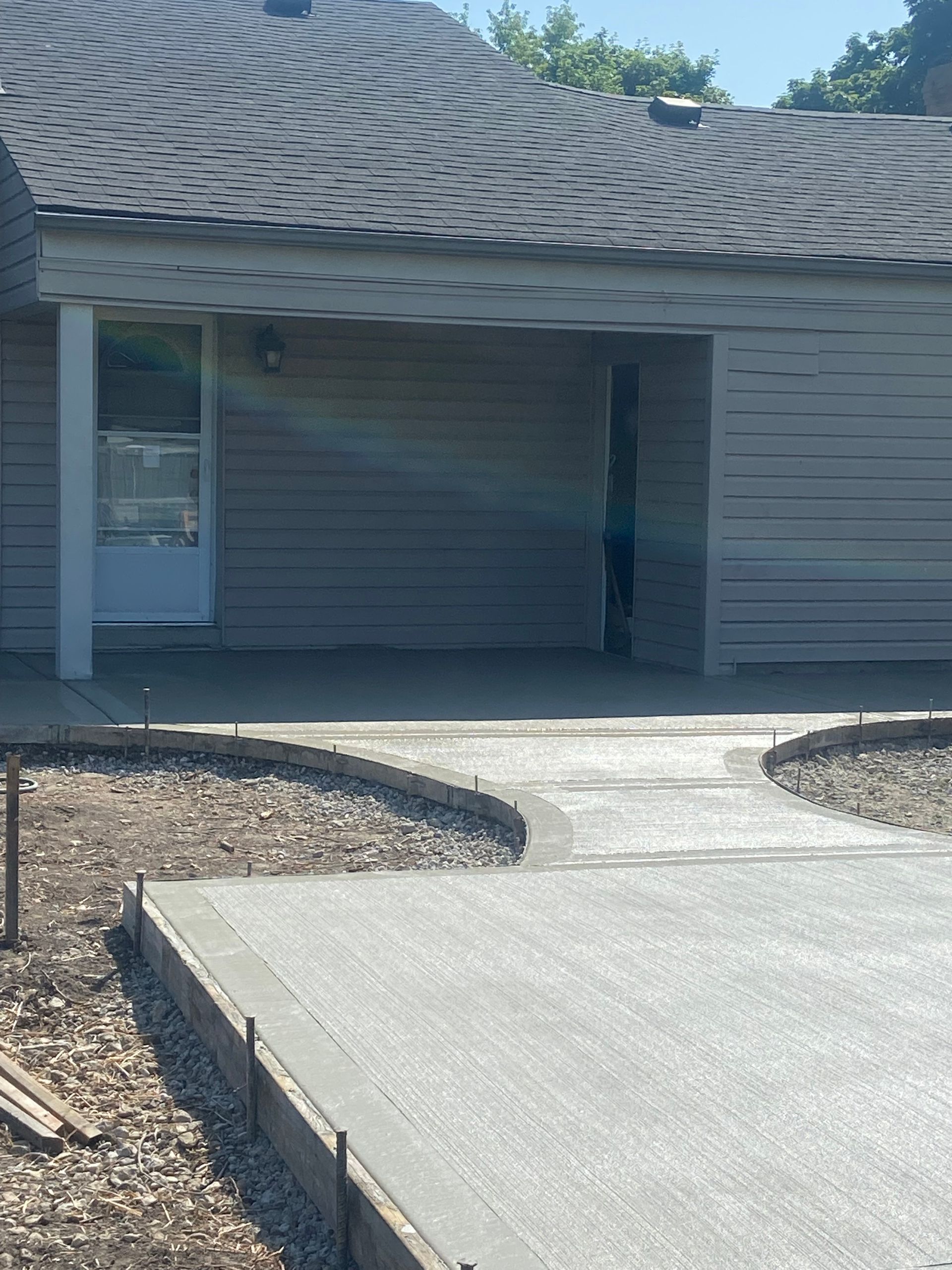 A house with a concrete driveway in front of it