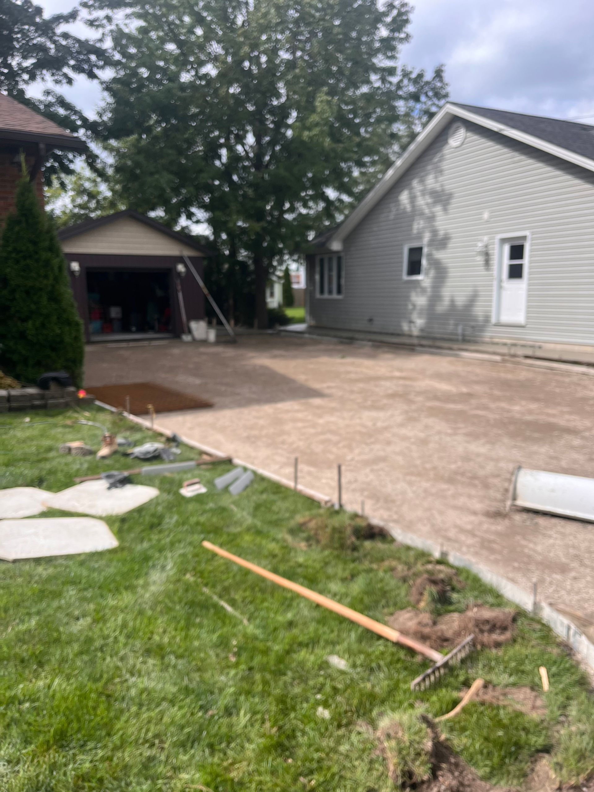 A concrete driveway is being built in front of a house.