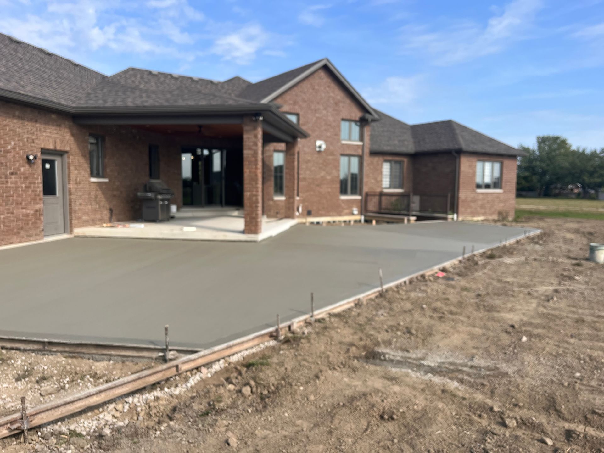 A large brick house with a concrete driveway in front of it.