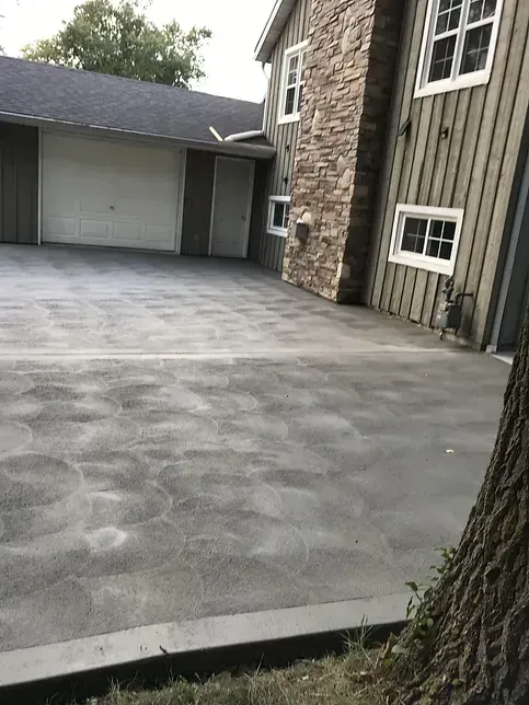 A large house with a concrete driveway in front of it.
