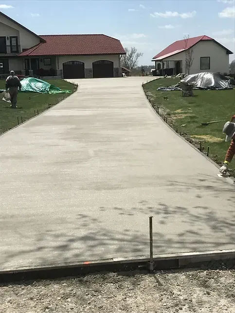 A concrete driveway is being built in front of a house.