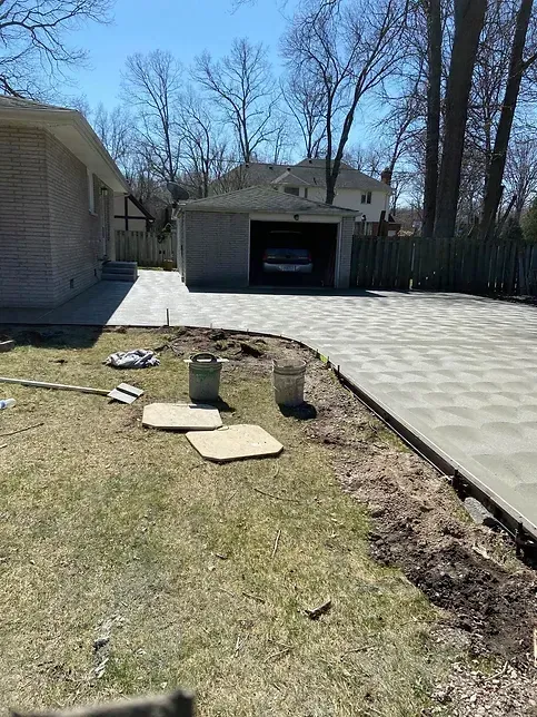 A concrete driveway is being built in front of a house.