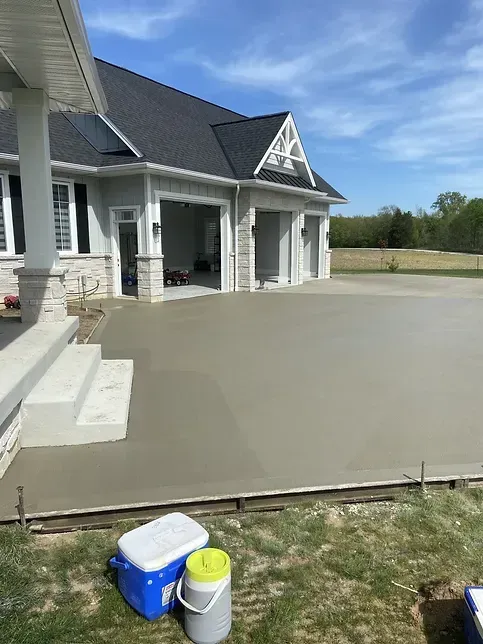 A concrete driveway is being built in front of a house.