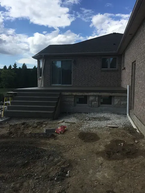 A house with a deck and stairs in front of it
