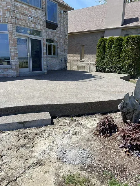 A concrete patio is being built in front of a house.