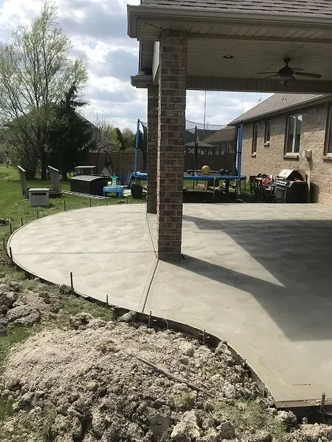 A concrete patio is being built in front of a house.