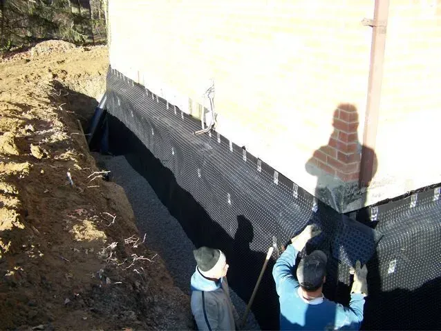 Two men are working on the side of a building