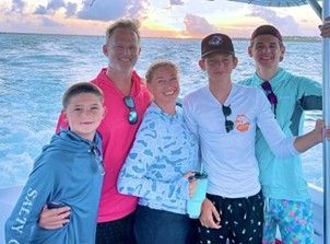 A family is posing for a picture on a boat in the ocean.