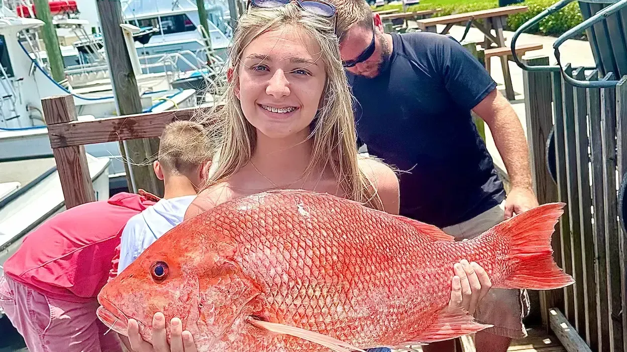 Red Snapper fishing Panama City Beach – girl showing big catch aboard Reel Groovy charter