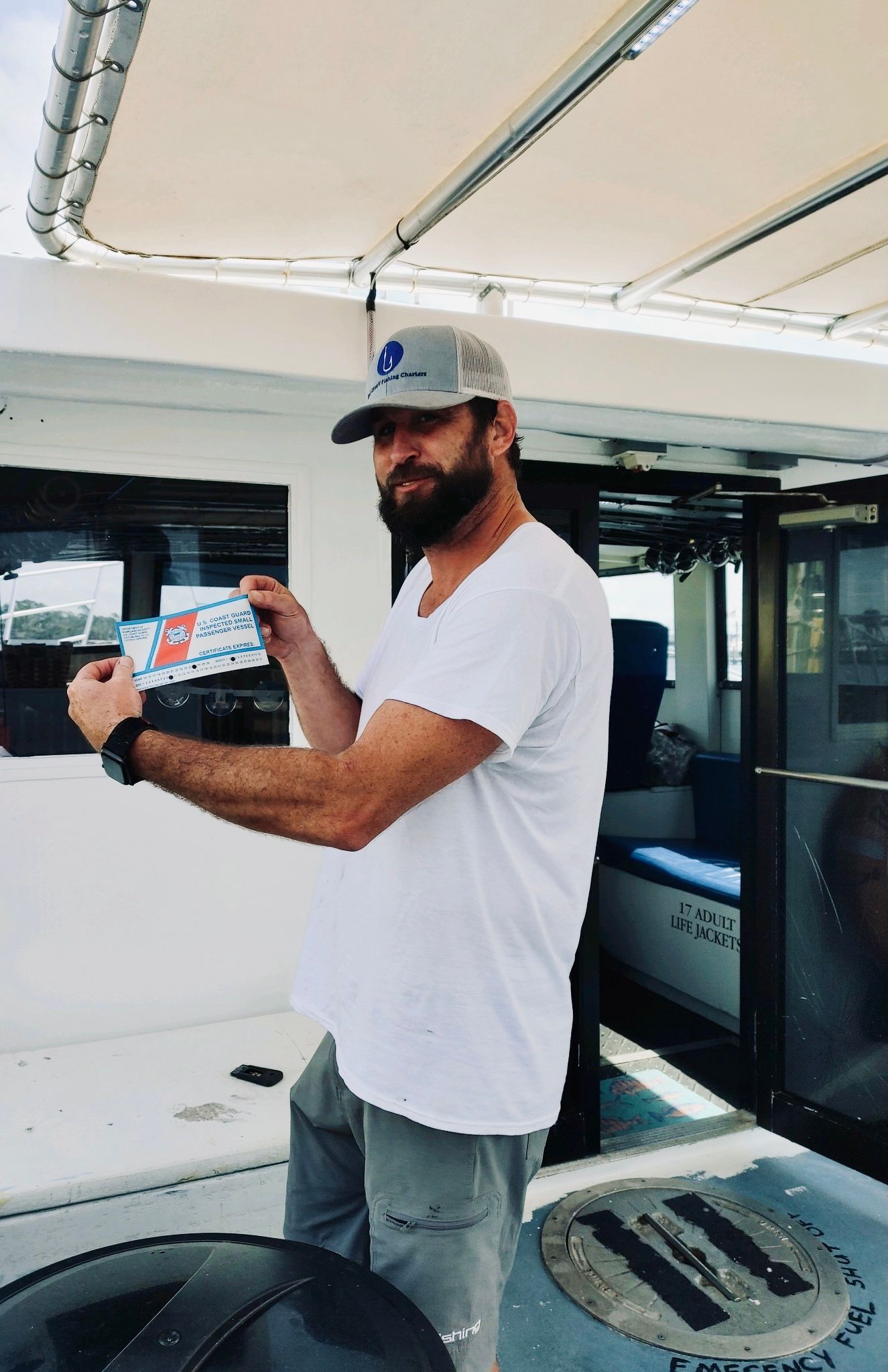 Captain Gary showing Coast Guard COI sticker for Reel Groovy fishing charter Panama City Beach