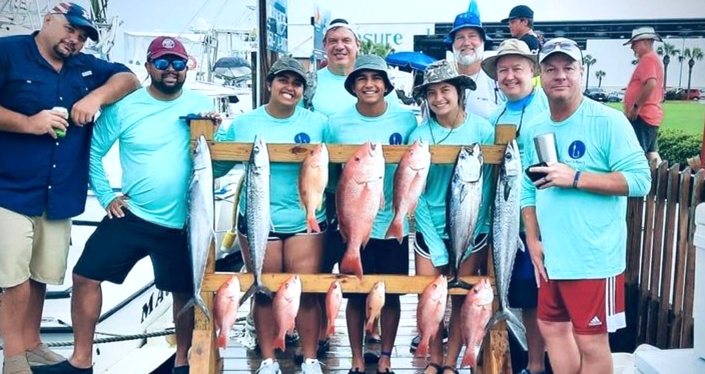 A group of young adults after a deep sea fishing charter with Reel Groovy Experiences in Panama City Beach, FL.