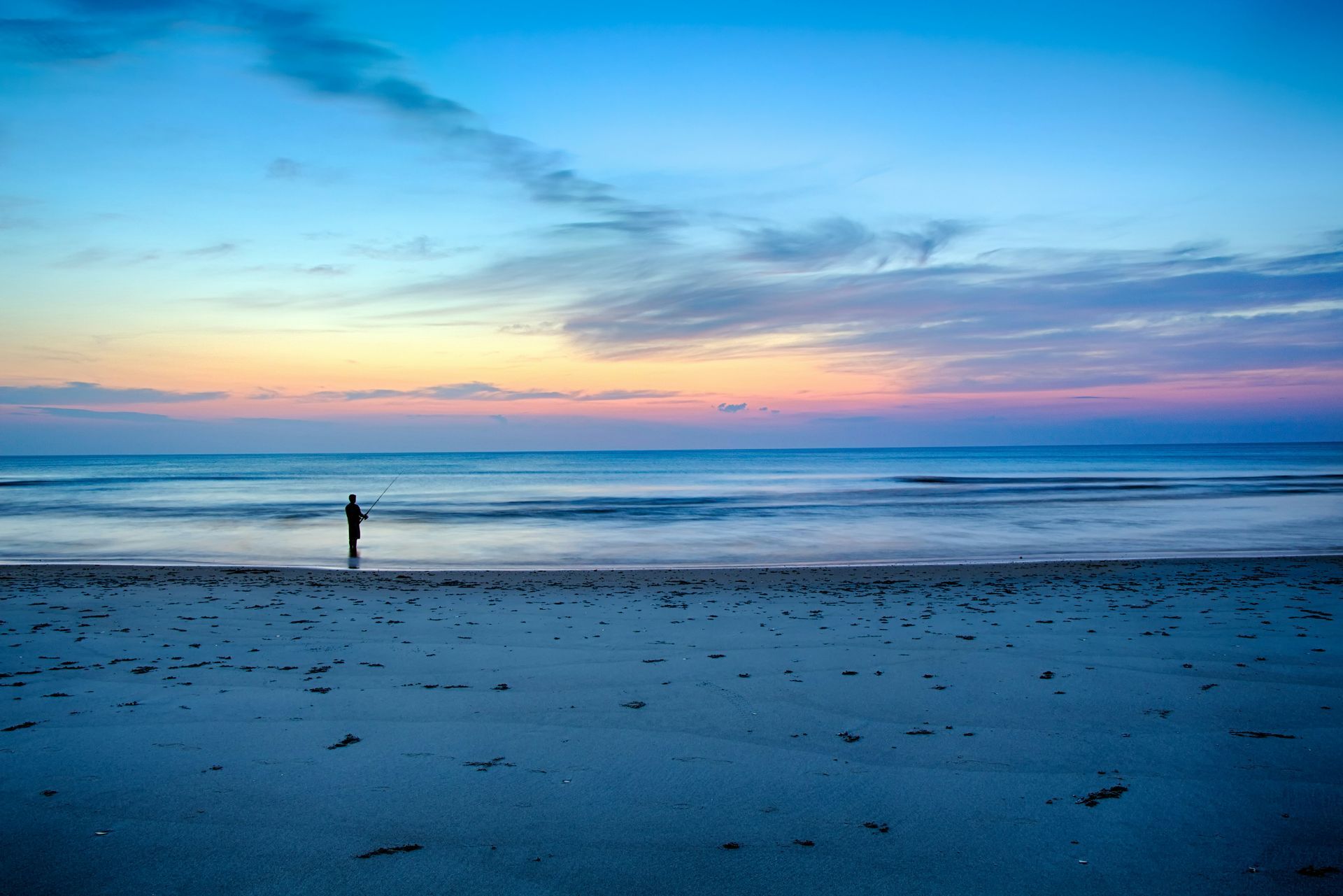 Person standing on sandy beach in Panama City Beach, Florida by the Gulf of Mexico/Gulf of America