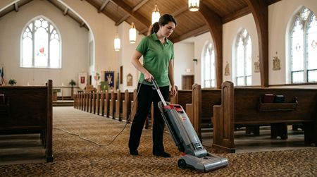 Cleaner vacuuming church carpet aisles between pew seating rows Edina, MN
