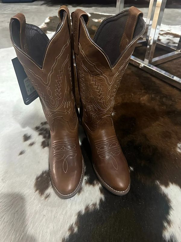 A Pair of Brown Cowboy Boots Are Sitting on Top of A Cowhide Rug — Country Charm in Charmhaven, NSW