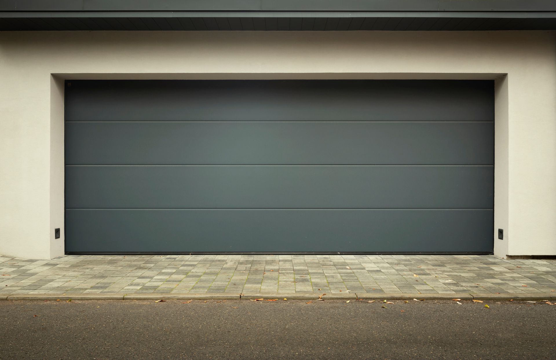 A large gray garage door is sitting in front of a house.