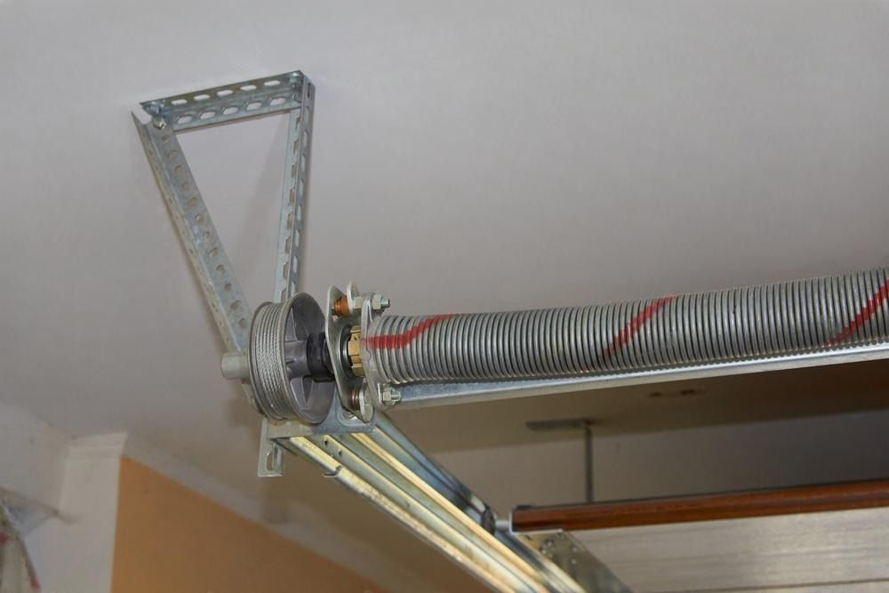 A close up of a garage door spring in a garage.