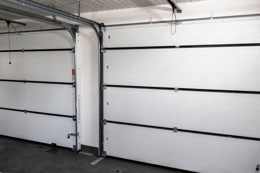 Two white garage doors are open in a garage.