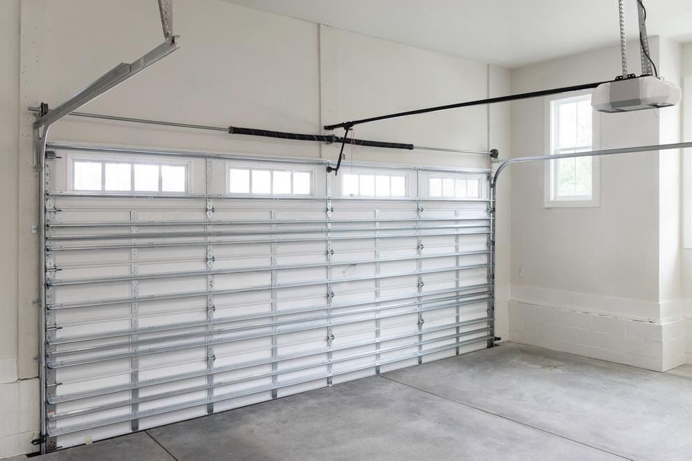 An empty garage with a garage door open and a garage door opener.