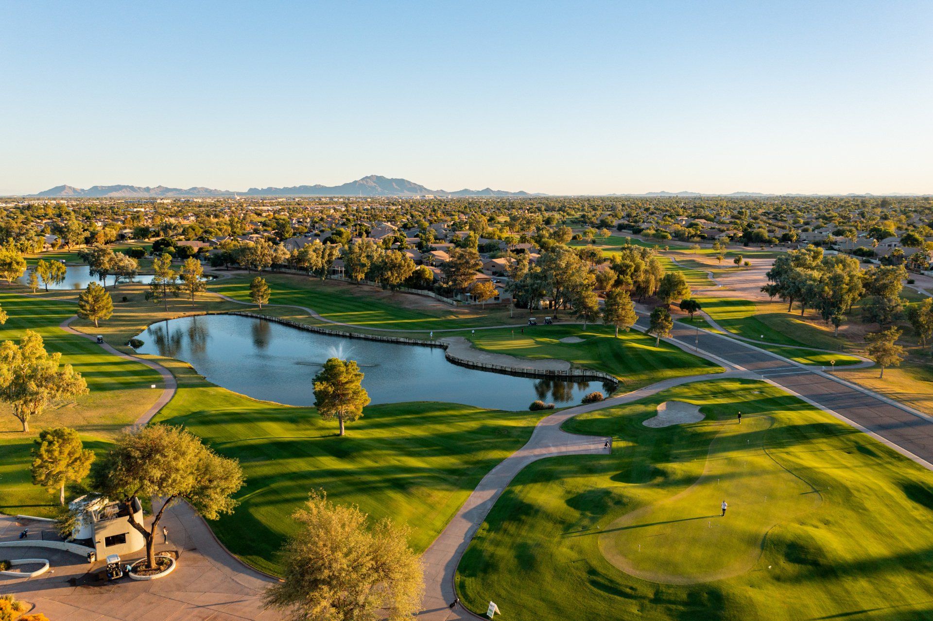 An aerial view of a golf course with a lake in the middle of it.