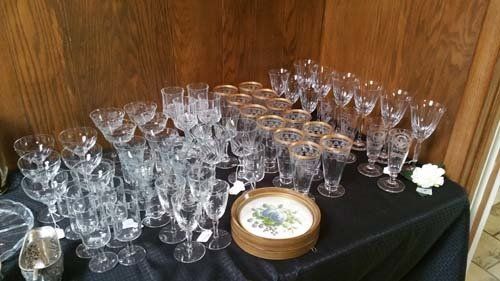 Table set with many crystal wine glasses and a stack of coasters.