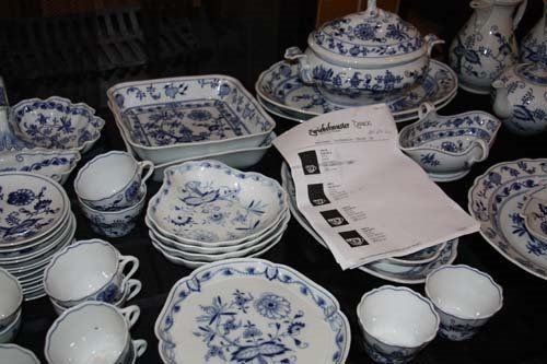 Blue and white china dishes arranged on a table, including cups, plates, and serving dishes.