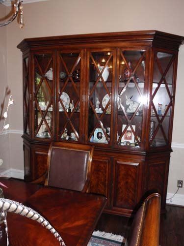 Wooden china cabinet with glass doors, displaying dishes.